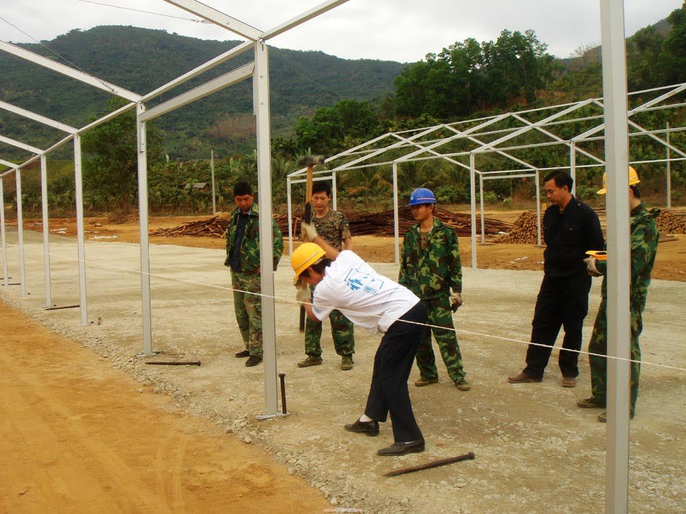 Steel Nails Fixed: "Steel nails driven into the ground to stabilize a temporary tent on a grassy surface."
